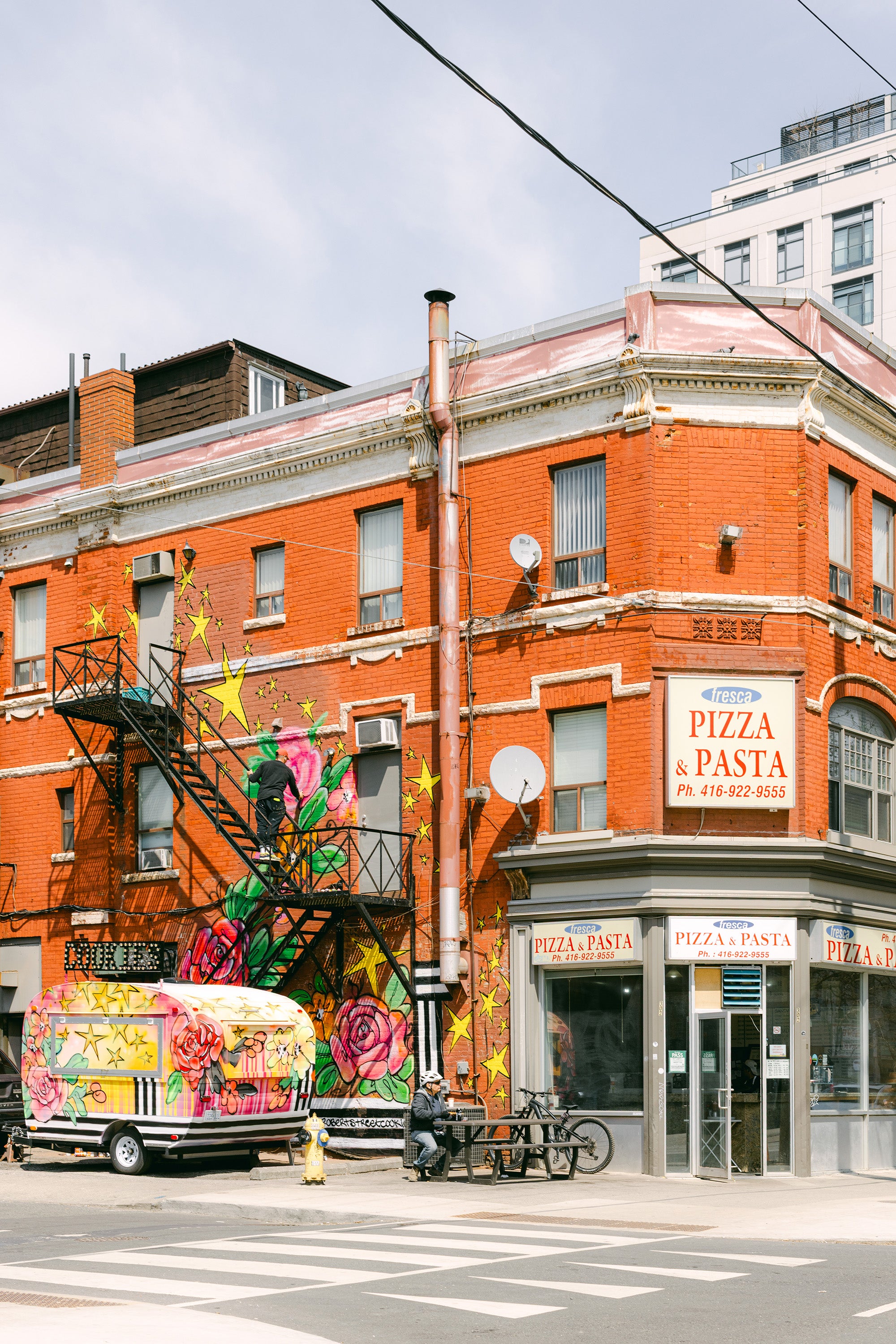 Colorful cookie camper parked in front of a brick building in Toronto.