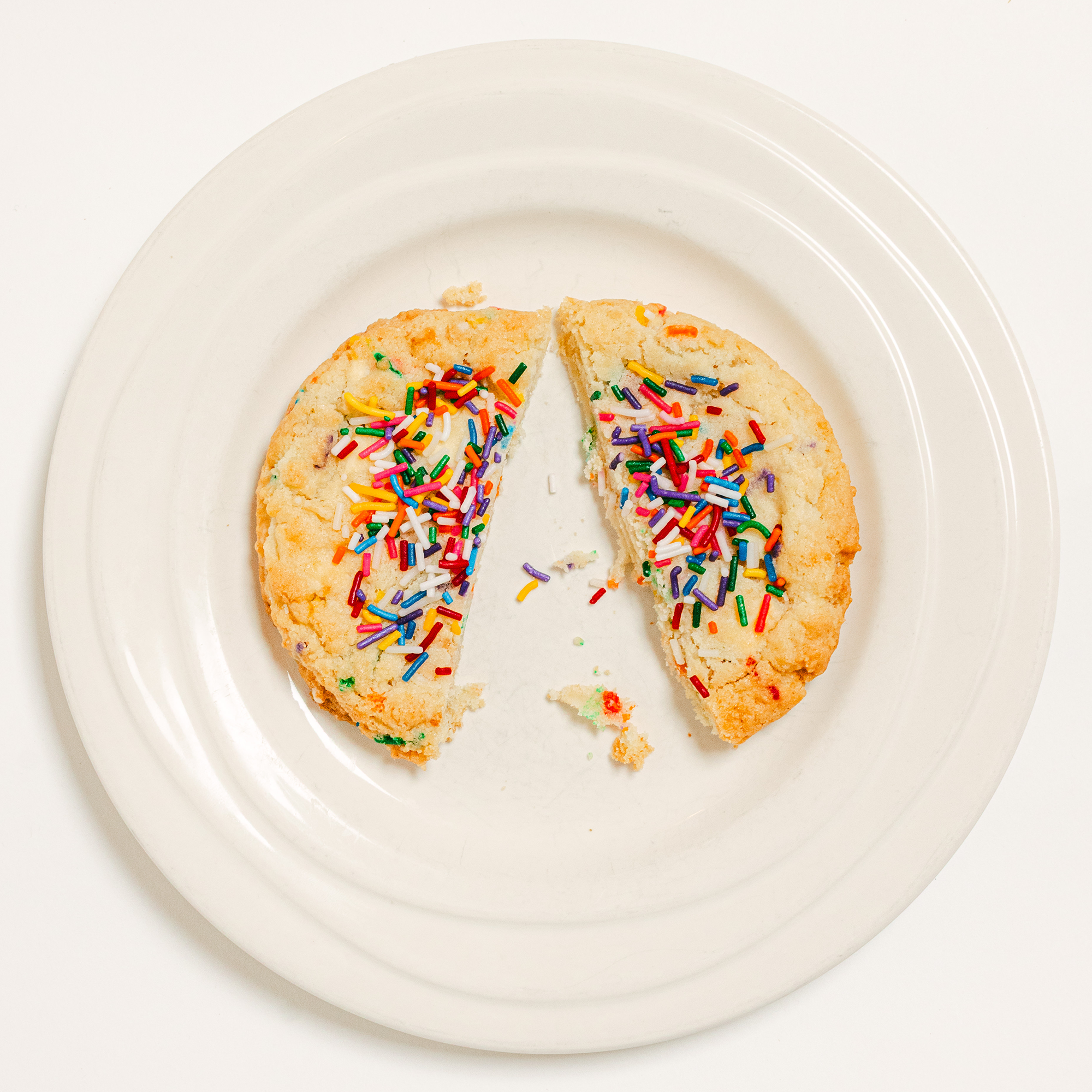 Robert Street Cookies Birthday Cake flavour cut in half on a white plate